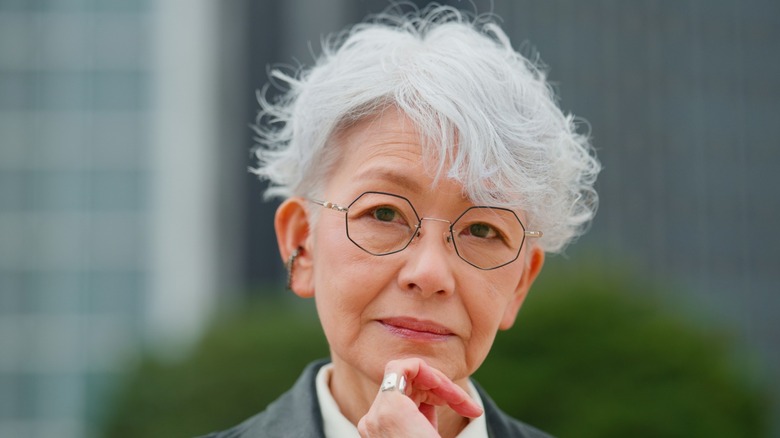 A woman with a light gray pixie cut and glasses.
