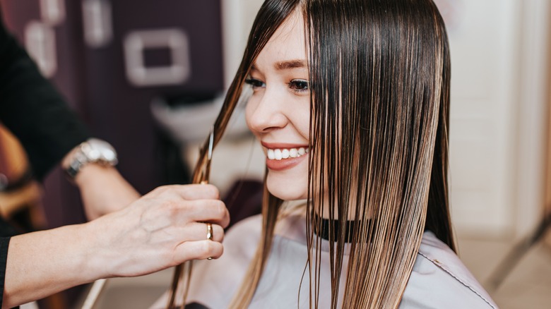Woman getting a haircut smiling long hair
