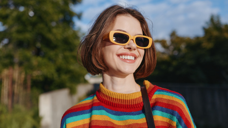 A woman with sunglasses and a blunt, red bob