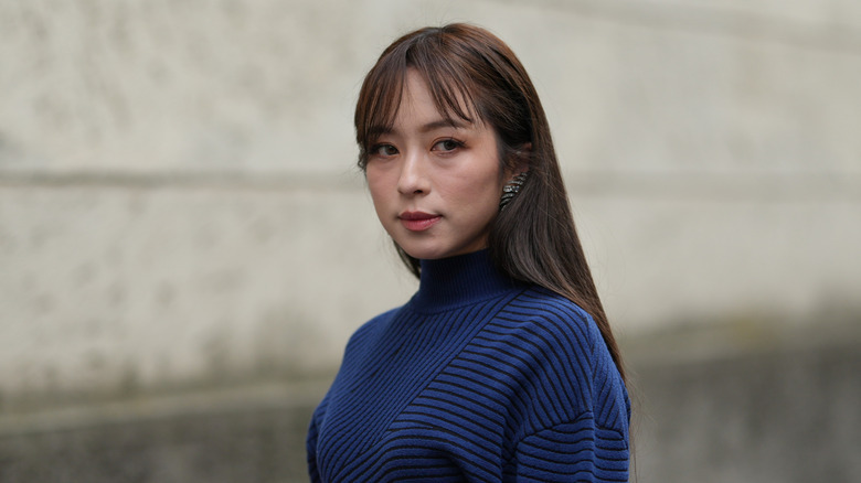 A woman with brunette curtain bangs and long straight hair