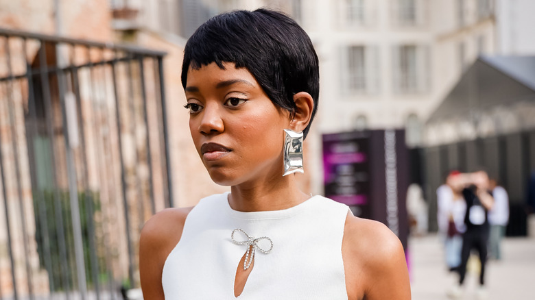 A woman with a black pixie wearing statement earrings