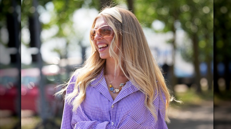 A woman with long blond layered hair wearing a headband