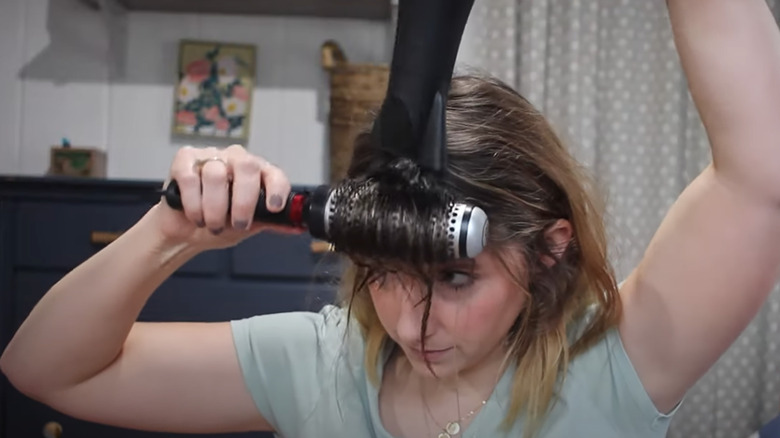 Woman blow drying curtain bangs