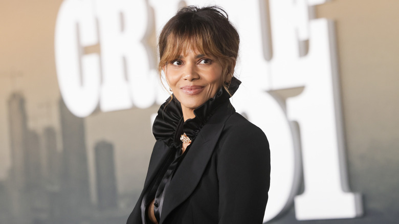 Halle Berry in a black suit jacket with a ruffled collar and her hair up