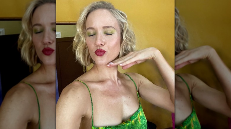 Jess Schram takes a selfie on set with green eye shadow and her lips puckered