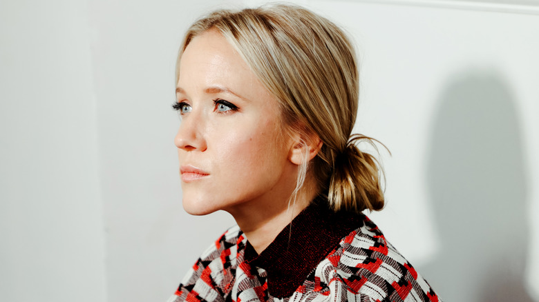 Jessy Schram sitting down looking across the room