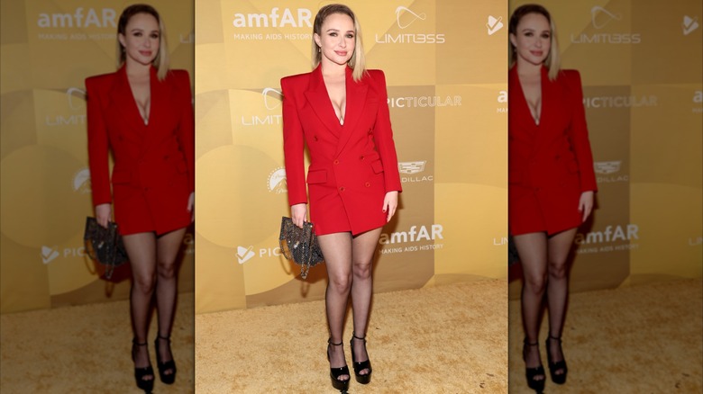 Hayden Panettiere wearing a sharp, red suit dress with black sandals and combed-over hair in November 2022.