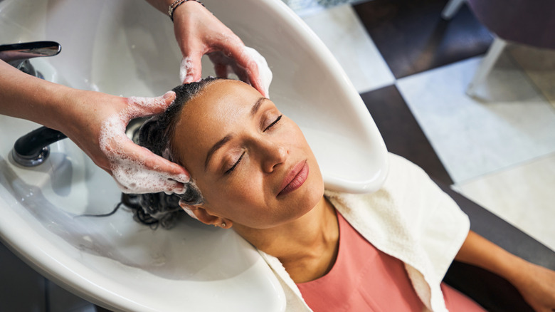 hairdresser washing woman's hair