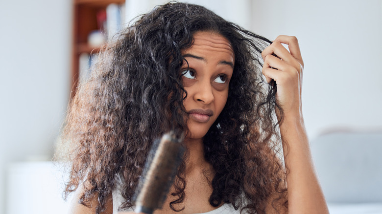 Unhappy woman looking at her hair