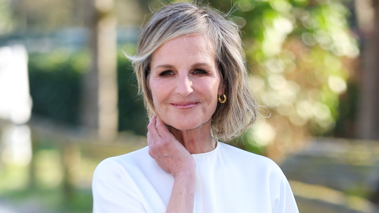 Helen Hunt wearing a white top with her graying blond hair swaying