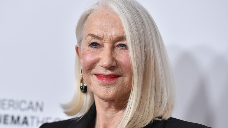Helen Mirren smiling on the red carpet with a sleek bob haircut.