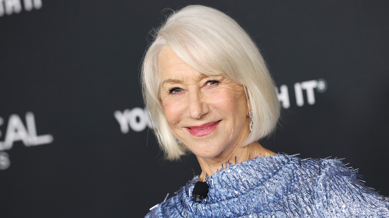 Actor Helen Mirren wearing a bob hairstyle and blue long-sleeved dress in at an event.