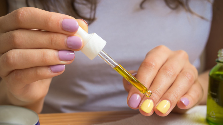 Person applying cuticle oil
