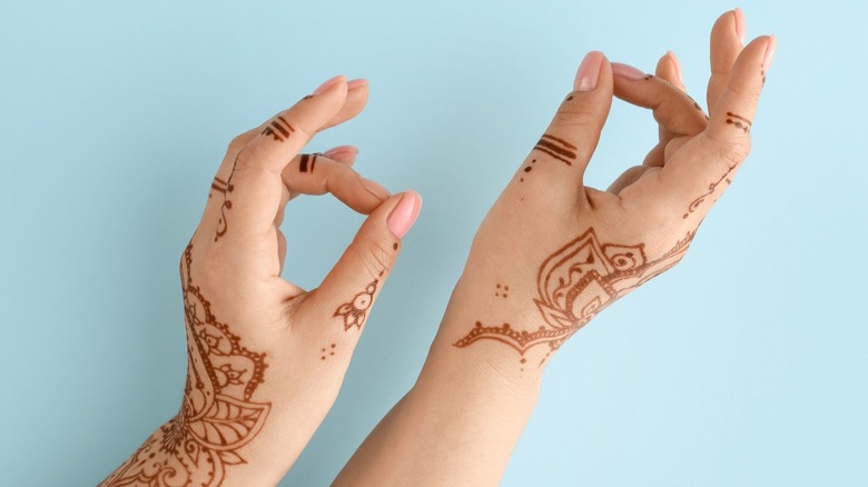 Hands with henna designs as temporary tattoos