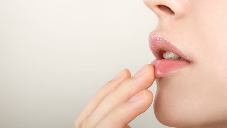 Woman touching her pink lips