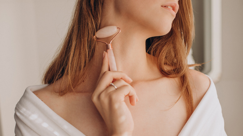 woman using jade roller 