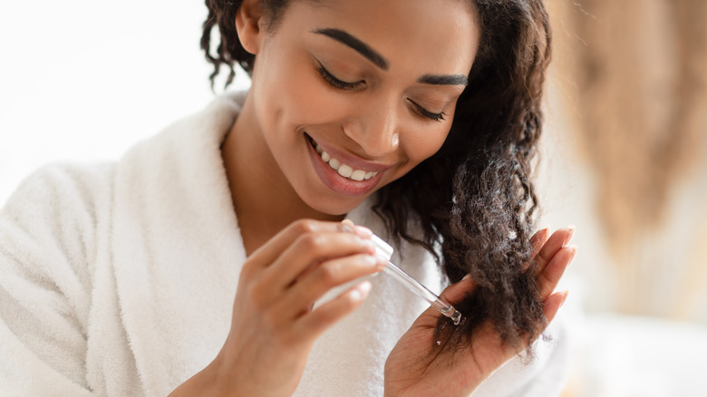 Woman using serum on her hair