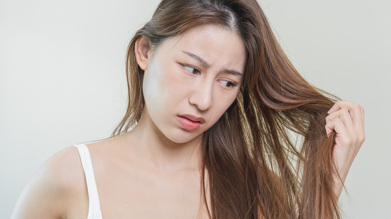 woman looking at damaged hair