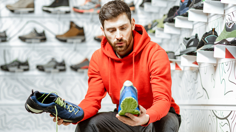 Man comparing shoes in store