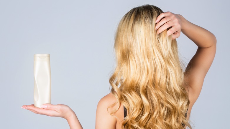 woman holding shampoo bottle