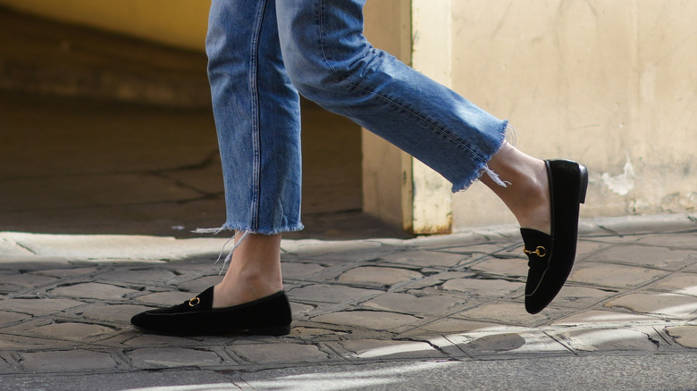 woman walking with frayed jeans