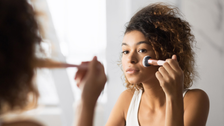 Model applying powder to face 