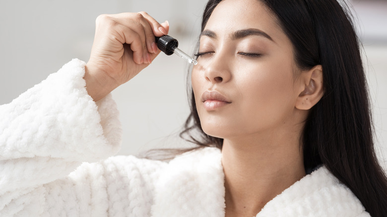 woman applying vitamin c serum