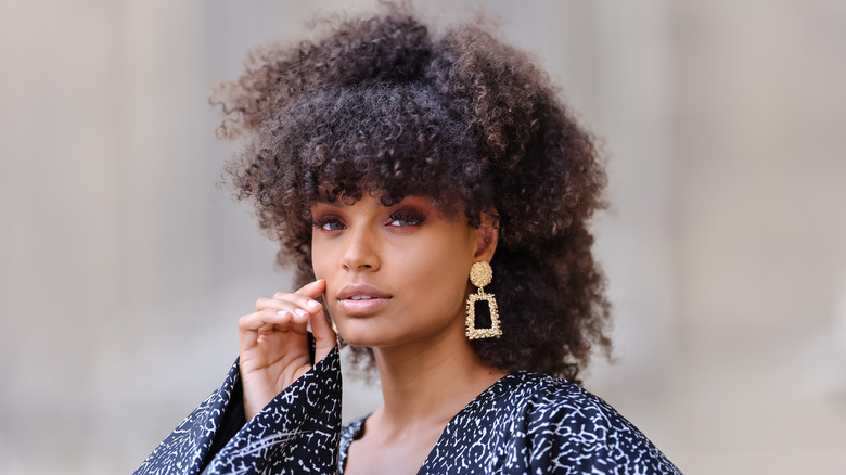 Woman with curly curtain bangs