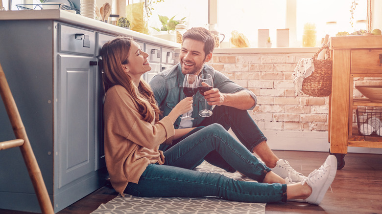 Couple in kitchen drinking wine