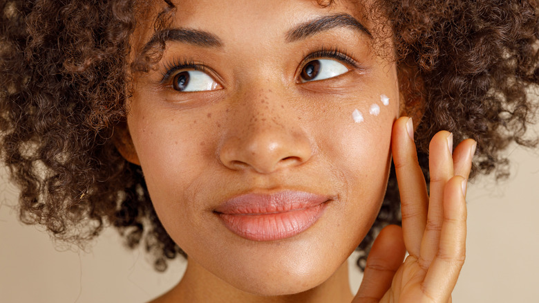 woman applying skincare product