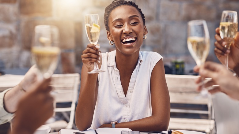 Woman drinks champagne with friends 