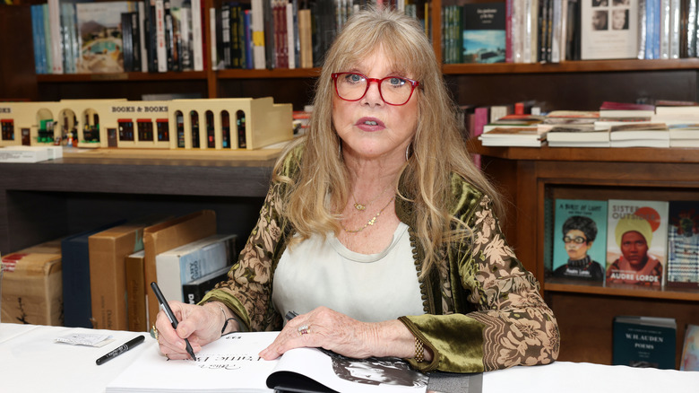 Pattie Boyd signs a copy of her book "Pattie Boyd: My Life in Pictures"