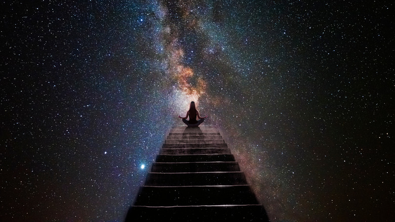 woman meditating with galaxy background