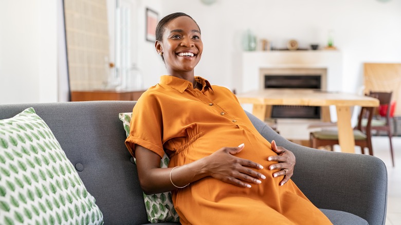 smiling pregnant woman on couch