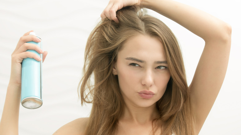 Woman spraying her hair