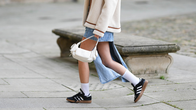 woman wearing black sneakers and skirt