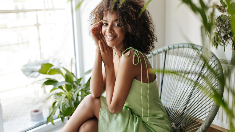 black woman behind plants smiling