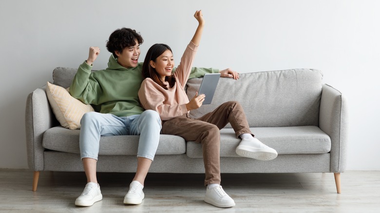 Couple sits together on couch 
