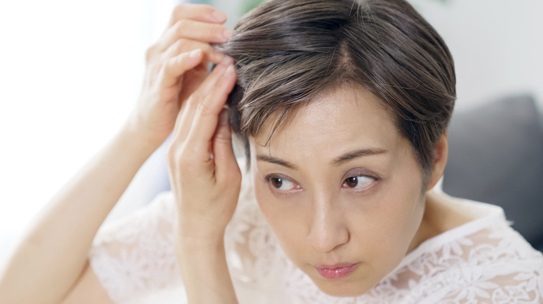 Model examining thinning hair