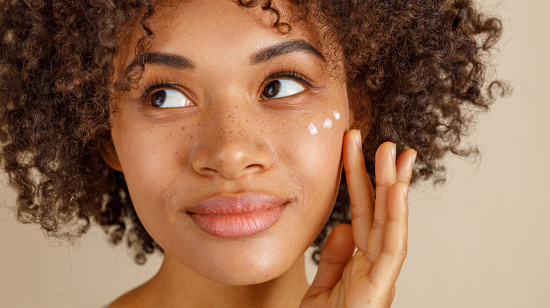 Woman with skincare product on face