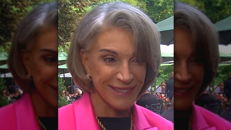 A Instagram video still of Hilary Farr being interviewed outside wearing a bright pink blazer.