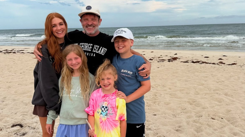 Jenn Todryk with her husband and kids posing at the beach