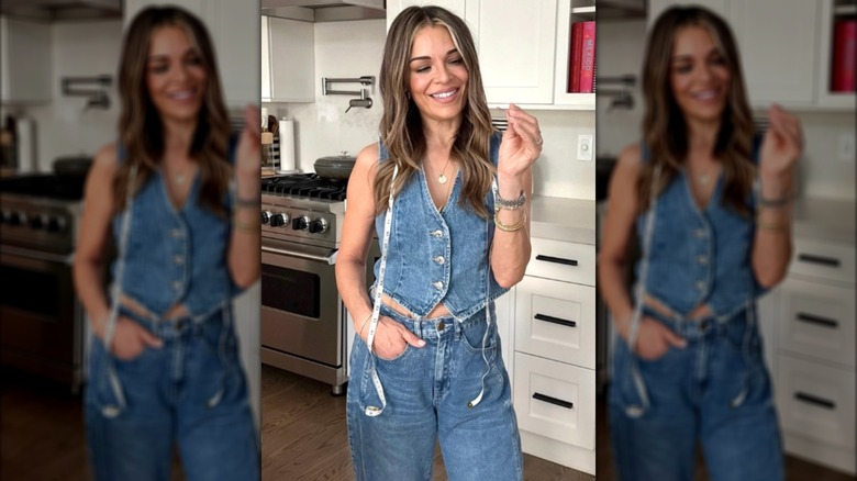 Sabrina Soto wearing a denim vest and jeans with a tape measure around her neck posing in a kitchen.