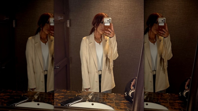 Chelsea DeBoer wears a cream fringe blazer