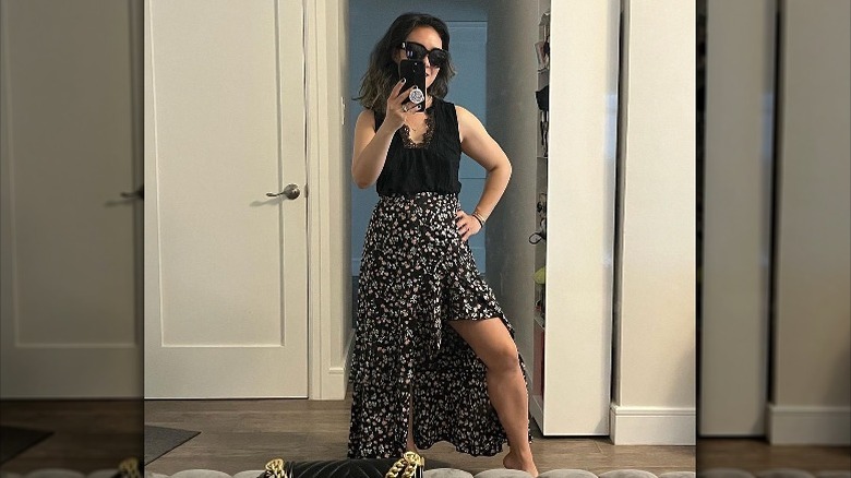 Woman wearing dark floral high-low skirt