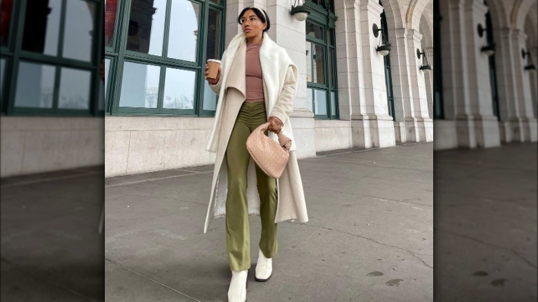 Model wearing cream coat and olive leggings