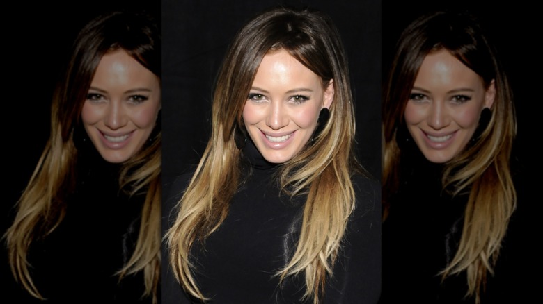 Hilary Duff smiling wearing a black top in 2011