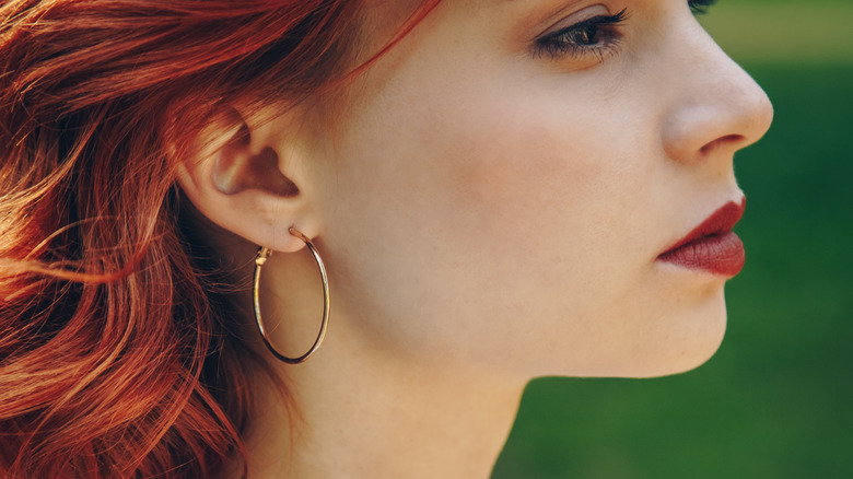 Shiny hoop earring on red head