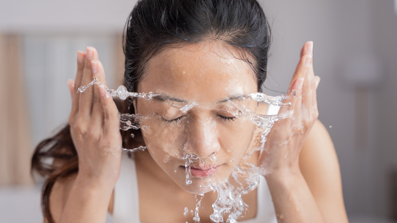woman splashing water on her face