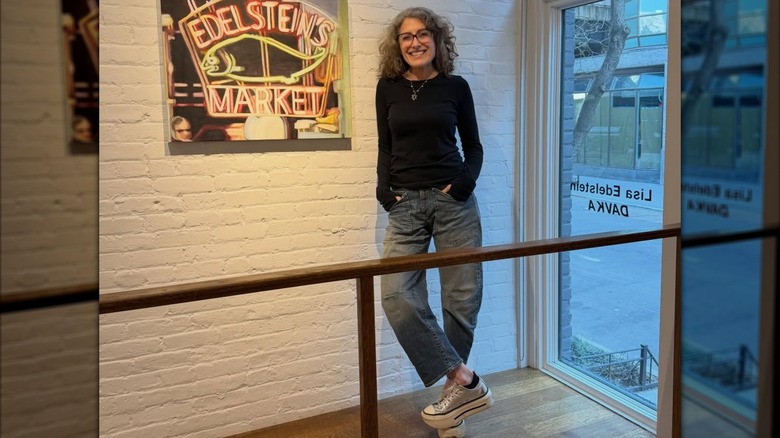 Lisa Edelstein next to an Edelstein's Market neon sign on March 2026